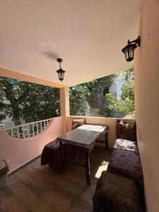 a balcony with a table and a bench in a room at Maja Apartmani in Sutomore