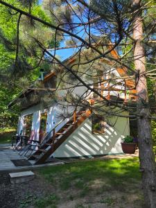 a small white house with a porch and stairs at Dolina Izerów in Sucha