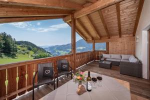 a porch with a table and chairs and a couch at Moarlhof - Farm Nature Resort in Castelrotto