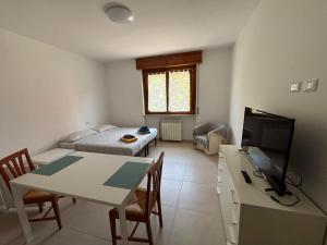 a living room with a table and a tv and a couch at RESIDENCE Erminia in Novara