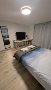 a bedroom with a bed and a desk with a computer at HOME HOSE in Monistrol-sur-Loire