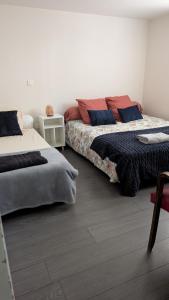 a bedroom with two beds and a table with a chair at HOME HOSE in Monistrol-sur-Loire