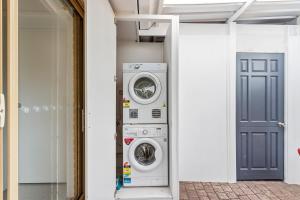 a hallway with two washing machines and a blue door at Golfside Getaway 2 by Ready Set Stay in Rosebud +3 photos