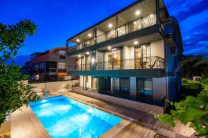 an exterior view of a house with a swimming pool at Demirel Suites Antalya-Lara Plajlar ve Havalimanına Yakın in Lara