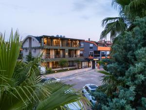 a building with cars parked in a parking lot at Demirel Suites Antalya-Lara Plajlar ve Havalimanına Yakın in Lara