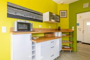 a kitchen with yellow walls and a counter with a microwave at Maison Au Petit Bonheur in Argenton-sur-Creuse