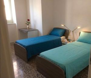 a room with two beds and a table with a lamp at L'appartamento di Tricase in Tricase