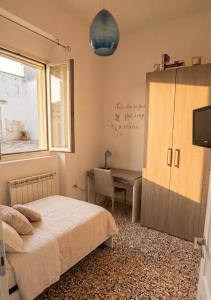 a bedroom with a bed and a desk and a window at L'appartamento di Tricase in Tricase
