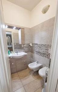 a bathroom with two sinks and a toilet and a mirror at L'appartamento di Tricase in Tricase