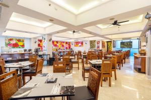 a restaurant with tables and chairs in a room at 1O1 URBAN Jakarta Thamrin in Jakarta