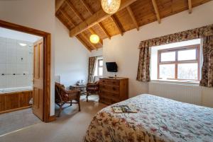 a bedroom with a bed and a desk and a window at Parr Hall Farm, Eccleston in Chorley