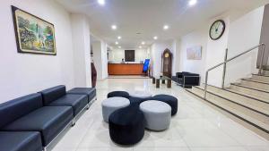 a living room with a couch and stools in it at Grand Orchid Hotel Solo in Solo