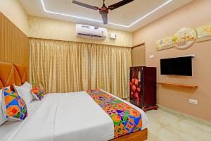 a bedroom with a bed and a flat screen tv at FabHotel Royal Atlantis Studio Apartments in Chennai