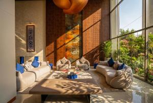 a living room with couches and a large window at Twelve Hotel in Baghdād