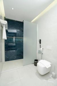 a white bathroom with a toilet in a room at Twelve Hotel in Baghdād +27 photos