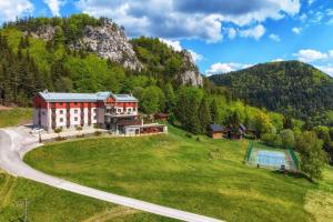 an aerial view of a house on a grassy hill at Hotel Malina - Ski & Bike resort in Ružomberok