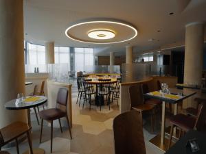 a restaurant with tables and chairs in a room at Suite in Premier Thermal Spa Resort in Châtel-Guyon