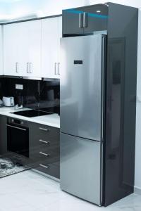 a stainless steel refrigerator in a kitchen with white cabinets at Aurelio Luxury Apartments in Paloúkia