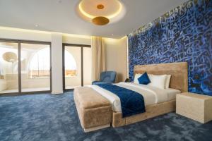 a bedroom with a bed and a blue wall at Twelve Hotel in Baghdād