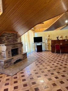 a living room with a stone fireplace and a piano at The House Hotel Goris in Goris