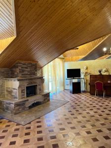 a living room with a stone fireplace and a television at The House Hotel Goris in Goris