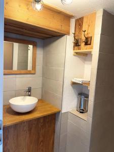 a bathroom with a white sink and a mirror at Le repaire de l'horloger in Maîche