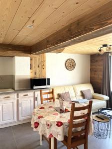 a room with a table and a couch and a kitchen at Le repaire de l'horloger in Maîche