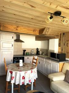 a kitchen with a table with chairs and a couch at Le repaire de l'horloger in Maîche +15 photos