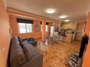 a living room with a couch and a kitchen at Las Delicias de Estepona in Estepona