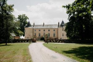 an old castle with a dirt road in front of it at Studio de Bresteau in Beillé