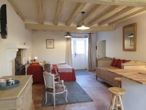 a living room with a couch and a bed and a table at Studio de Bresteau in Beillé