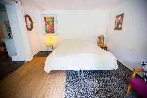 a bedroom with a white bed and a wooden floor at Private 2 prs basement I spacious & central CPH in Copenhagen
