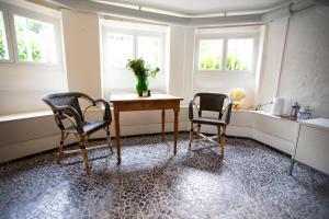 a dining room with two chairs and a table and two windows at Private 2 prs basement I spacious & central CPH in Copenhagen