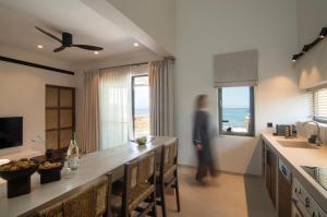 a person walking through a kitchen with a view of the ocean at AÁSHNA Suites and Residences in Vaia