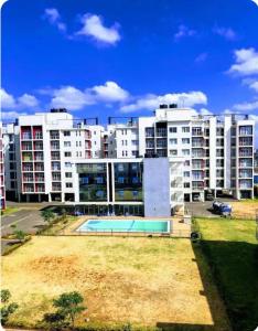 a large apartment building with a pool in front of it at Luxe Haven in Nairobi