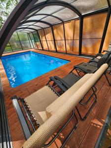 a deck with chairs and a swimming pool at Chata Roubenka in Sedloňov