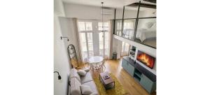 a living room with a couch and a bed and a fireplace at Doux Pavillon - Le Loft d'Or in Nice