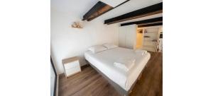 a small bedroom with a white bed and a closet at Doux Pavillon - Le Loft d'Or in Nice