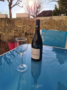 a bottle of wine and two glasses on a table at Joly Gîte in Les Bois