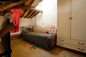 a small bedroom with a bed and a dresser at Hotel Corallo in Pomonte