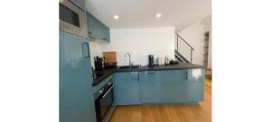 a kitchen with blue cabinets and a stove at Doux Pavillon - Le Loft d'Or in Nice +5 photos
