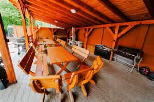 a group of wooden tables and chairs in a room at Chata Roubenka in Sedloňov