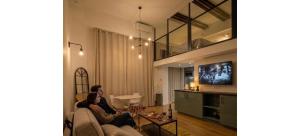 two people sitting on a couch in a living room at Doux Pavillon - Le Loft d'Or in Nice