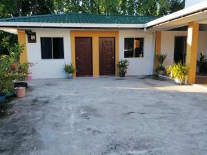 a house with two brown doors and some plants at HG Homestay in Kota Kinabalu