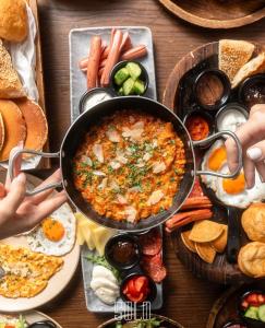 ein Tisch voller Essen mit einem Topf Essen in der Unterkunft SOLO Hotel in Prizren