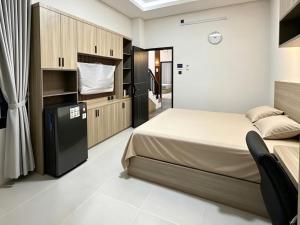a bedroom with a large bed and cabinets at D'CIA Coliving in Kejayan