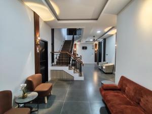 a living room with a couch and a staircase at D'CIA Coliving in Kejayan