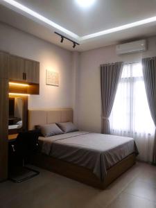 a bedroom with a large bed and a window at D'CIA Coliving in Kejayan +16 photos
