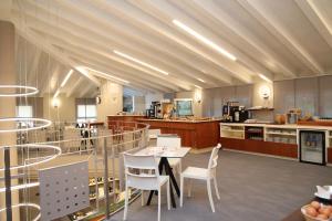 a large kitchen with a table and chairs at LVG Hotel Collection - Riz in San Genesio ed Uniti
