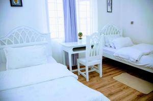 a bedroom with two beds and a desk and a desk at Tatu City Serene 2BR Apartment in Tatu City +26 photos